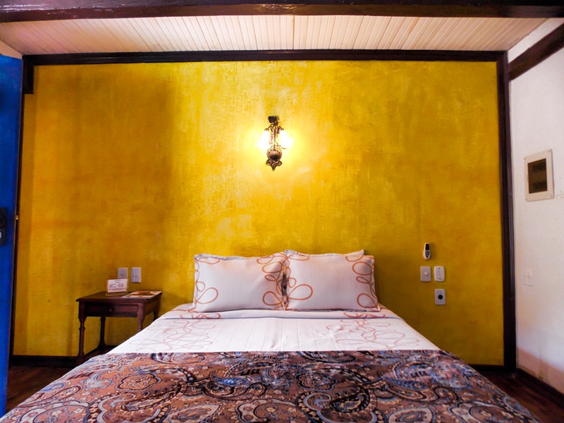foto-apresenta-uma-cama-box-com-parede-em-tecna-patina-amarela